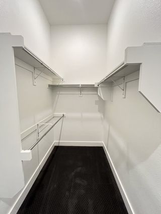 Model Home A spacious walk-in closet with sleek shelving and carpeted flooring, perfect for organized storage.