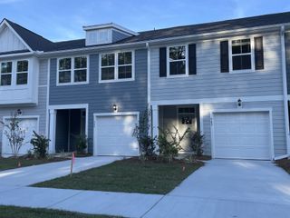 A charming, modern townhouse with blue-gray siding in Boykins Run Townhomes by DRB Homes (Moncks Corner, SC).