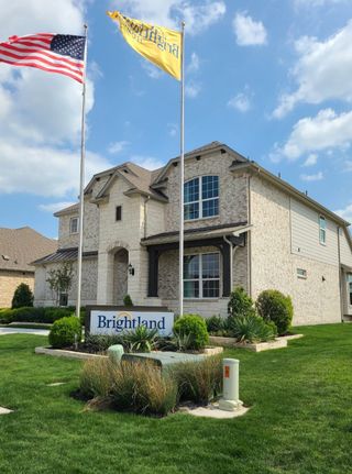 Street view A beautiful two-story brick home with lush landscaping in Anna Ranch by Brightland Homes (Anna, TX).