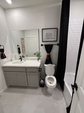 Modern bathroom with sleek cabinetry, bright lighting, and stylish black accents creating a contemporary and inviting space.