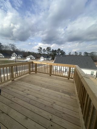 A spacious wooden deck overlooking a suburban neighborhood with houses and trees under a cloudy sky in Dacula, GA.