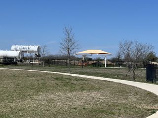 Community Amenities Expansive outdoor area with a canopy and paths in Crosswinds by Milestone Community Builders, Kyle, TX.