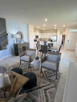 Model Home A beautifully designed open-concept living and dining area with cozy seating, stylish decor, and a modern kitchen for seamless entertaining.