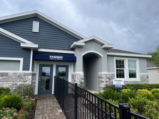 Street view A beautifully designed model home with stone accents, lush landscaping, and a welcoming entry in Westgate at Avalon Park by D.R. Horton.
