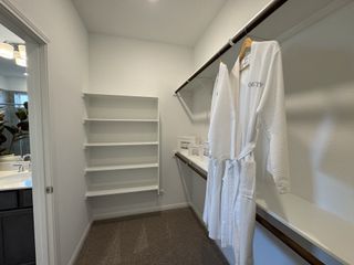 A well-organized walk-in closet with built-in shelves and ample storage, ensuring a stylish and clutter-free space.