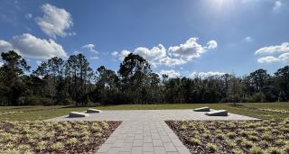 Beautiful green landscape and paved path under a bright blue sky in Harmony West by D.R. Horton (St. Cloud, FL).