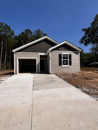 A modern taupe siding home with a single garage in Back River Bend by D.R. Horton (Goose Creek, SC).
