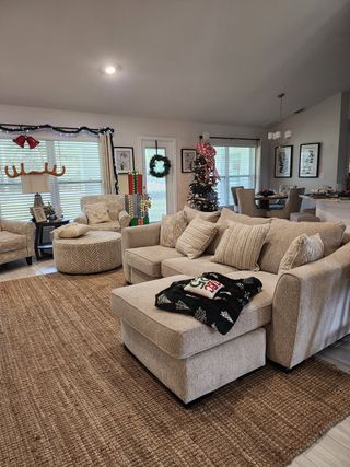A cozy living room decked out for the holidays, featuring a Christmas tree and festive décor.