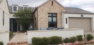 Street view A charming brick home with a landscaped pathway in Stone Crest by Camelot Homes (Gilbert, AZ).