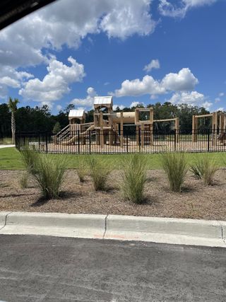Community Amenities A beautiful community playground surrounded by landscaped greenery in Hewing Farms by Mungo Homes (Summerville, SC).