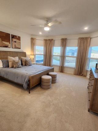 A serene bedroom with neutral tones, elegant drapery, and stylish furnishings, creating a cozy and inviting atmosphere.
