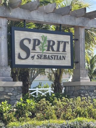 Lush greenery surrounds this welcoming entrance sign for Spirit of Sebastian by Ryan Homes, located in Sebastian, FL.