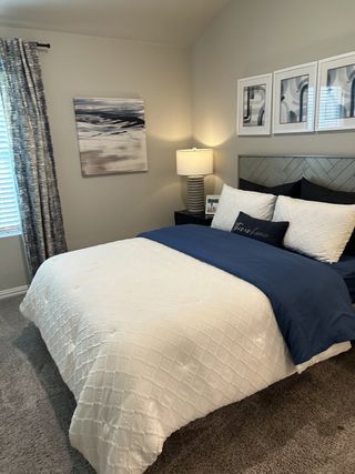A tranquil bedroom with a plush bed, deep blue accents, and modern artwork, creating a peaceful retreat.