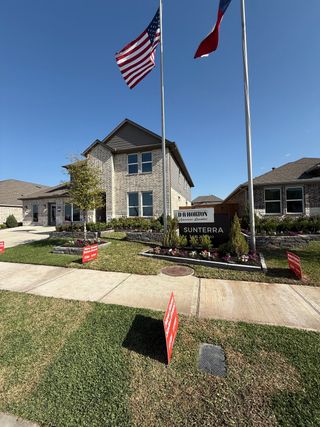 Street view A beautiful brick home with manicured landscaping in Sunterra by D.R. Horton, nestled in Katy, TX.