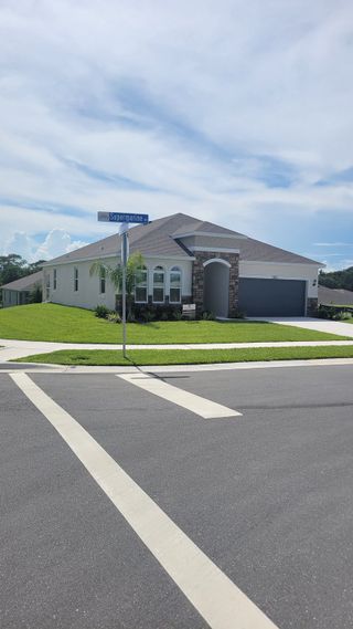 Street view A charming home with stone accents and lush lawn in Seaport Village by Dream Finders Homes (Tavares, FL).