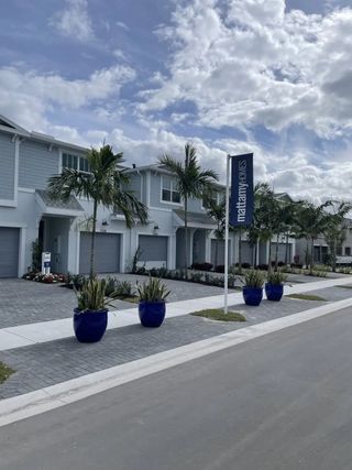 A modern townhouse with palm-lined streets in Forest by Mattamy Homes, Lake Worth, FL.