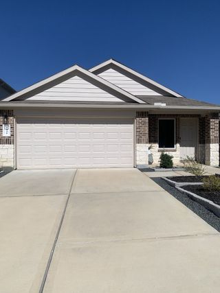Model Home A charming brick and stone home with a wide driveway in Breckenridge Forest by D.R. Horton (Spring, TX).