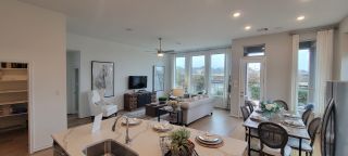 An inviting open-concept living area with elegant decor, large windows, and a cozy dining space perfect for gatherings.