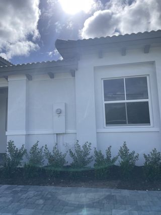 Street view A modern white home with neat landscaping in Silverland Estates by Lennar (Miami, FL).