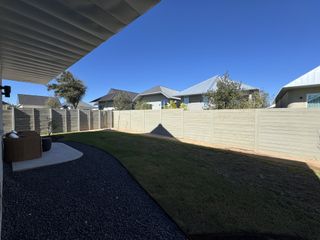 Street view A well-maintained backyard with a seating area and privacy fence in Wolf Ranch: Genesis Collection by Lennar (Georgetown, TX).