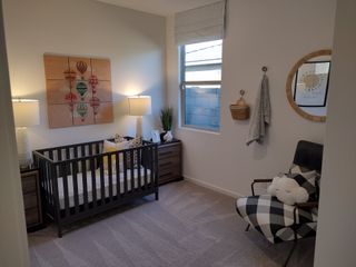 Model Home A cozy nursery featuring a black crib, twin lamps, and playful hot air balloon art.