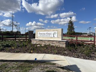 A welcoming entrance to Twisted Oaks by Pulte Homes in Wildwood, FL, featuring manicured landscaping and a charming sign.