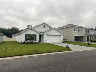 A charming white home with a manicured lawn in Autumn Glen by D.R. Horton (Belleview, FL).