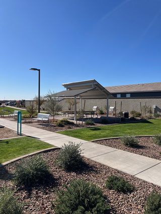 A beautifully landscaped park with seating in The Enclave on Olive by Meritage Homes, Waddell, AZ.