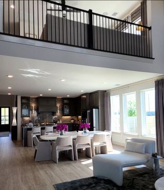 A spacious, modern open-plan living area with a stylish kitchen, elegant dining set, and a cozy lounge spot.