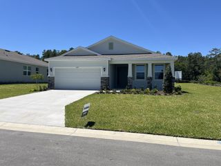Street view A charming modern home with a two-car garage and manicured lawn in JB Ranch by D.R. Horton (Ocala, FL).