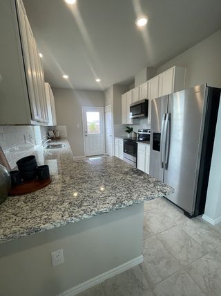 Modern kitchen with stainless steel appliances, granite countertops, and sleek cabinetry.