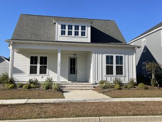 A charming white home with a welcoming porch in Nexton by Homes by Dickerson (Summerville, SC).