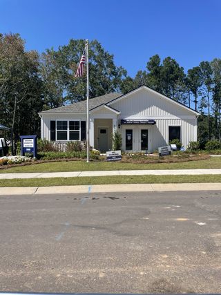 Street view A charming white home with a manicured lawn in Settlement at Salamander by D.R. Horton (North Charleston, SC).