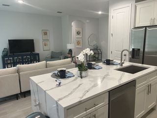 A modern, open-plan living area with a sleek kitchen island, cozy seating, and stylish decor.