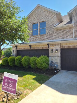 Street view A charming brick home with lush greenery in Villas of Middleton by Megatel Homes (Plano, TX).