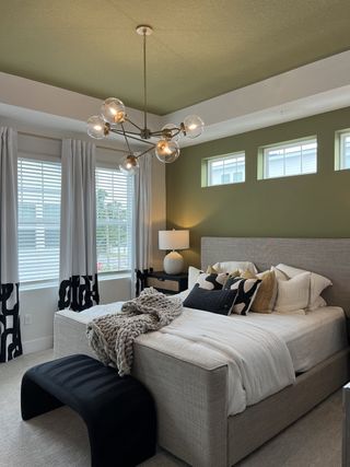 A chic bedroom with a plush bed, stylish pendant lighting, and modern decor accents.