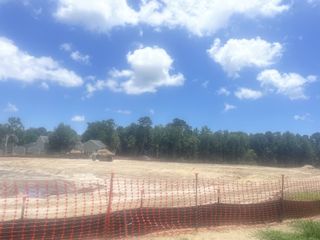 Upcoming construction site enveloped by trees in Miller's Crossing by Dream Finders Homes (Johns Island, SC).