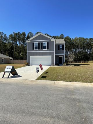 A modern gray two-story home with a spacious driveway in Evergreen by D.R. Horton (Holly Hill, SC).