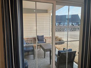 A cozy patio view with comfortable wicker seating and a serene backyard setting.