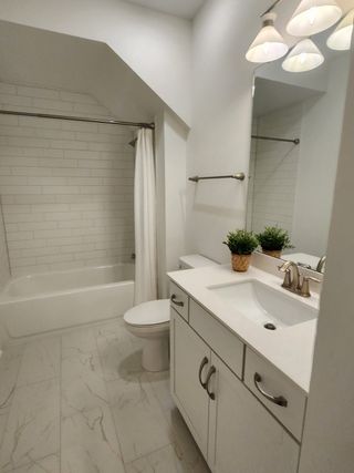 A sleek bathroom with white subway tiles, elegant vanity, and modern lighting creates a fresh and inviting atmosphere.