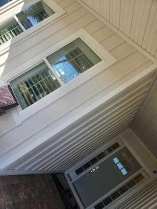 A welcoming front porch with beautiful landscaping and a light, modern facade that blends charm and simplicity.