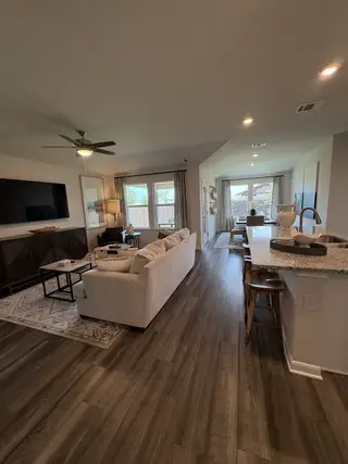 A modern, open-concept living area featuring wooden floors, cozy seating, and abundant natural light.