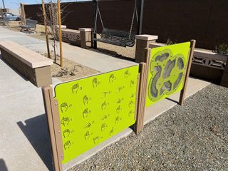 Colorful play area with educational signs and seating in El Rancho Santa Rosa by Centex (Maricopa, AZ).