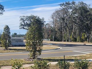 Inviting entrance with lush greenery in The Preserve at Concourse Crossing by Century Communities (Fernandina Beach, FL).