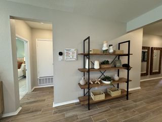 A modern entryway with sleek shelving, decorative vases, and wooden flooring.