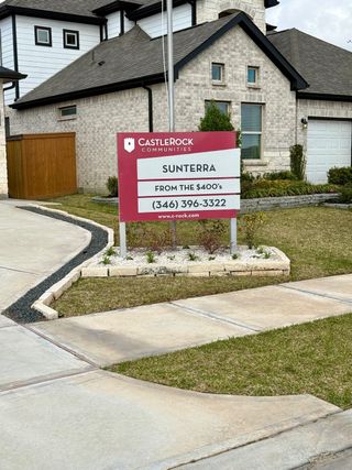 Street view A charming brick home with manicured landscaping in Sunterra by CastleRock Communities (Katy, TX).