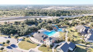 Aerial view of a lush community with a large pool and amenities in Santa Rita Ranch by Taylor Morrison (Liberty Hill, TX).