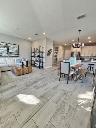 A modern open-plan living space with neutral tones, light wood flooring, and elegant decor.