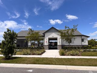 Model Home A charming clubhouse with stone accents and lush landscaping in Geneva Landings by Highland Homes of Florida (Davenport, FL).