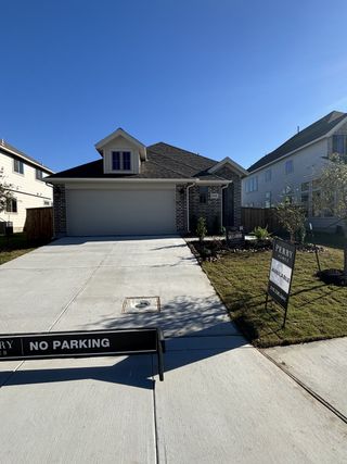 A charming brick home with a spacious driveway in The Parklands 50' by Perry Homes (Schertz, TX).